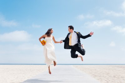 Couple Jumps: Beach Boardwalk Wedding